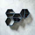 Set of 5 modular hexagon 3D-printed wall shelves in matte black arranged in a honeycomb display, HappyLayerMint Malta